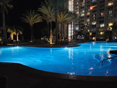 a large swimming pool with palm trees at night at Shores of Panama 0801 'Panama Dreamin' in Panama City Beach