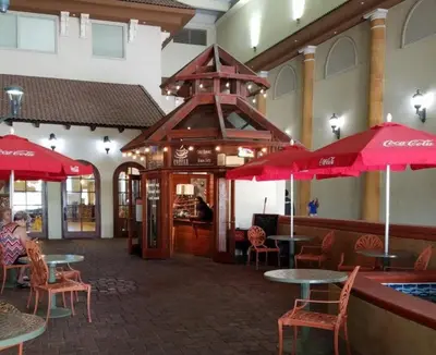a restaurant with tables and chairs and red umbrellas at Shores of Panama 0801 'Panama Dreamin' in Panama City Beach