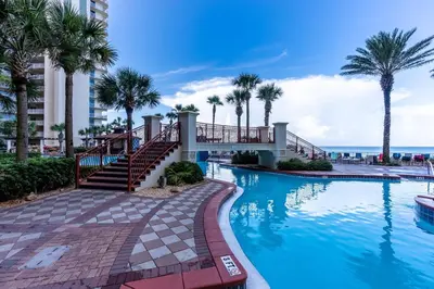 a swimming pool at a resort with palm trees at Shores of Panama 0201 'Down By the Sea' in Panama City Beach