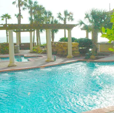 a swimming pool with palm trees in a resort at Shores of Panama 0817 'Sunset Lagoon' in Panama City Beach