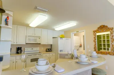 a kitchen with white cabinets and white appliances at Seychelles 1801 'Turtle Cay' in Panama City Beach
