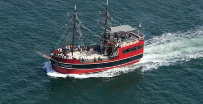 a red boat with people on it in the water at Seychelles 1801 'Turtle Cay' in Panama City Beach