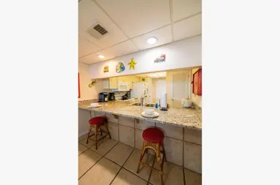 a kitchen with two stools and a counter top at Edgewater 2-0904 'Sea Breeze' in Panama City Beach