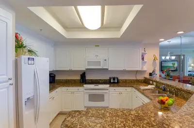 a kitchen with white cabinets and granite counter tops at Boardwalk 2111 'Seaside Memories' in Panama City Beach