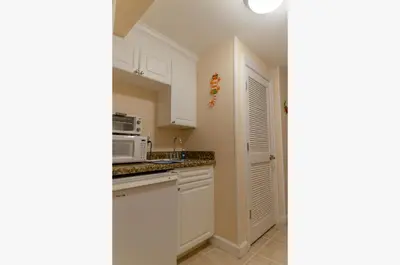 a kitchen with white cabinets and a microwave at Boardwalk 2111 'Seaside Memories' in Panama City Beach