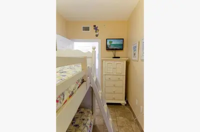 a bedroom with a bunk bed and a ladder to a bunk bed at Boardwalk 2111 'Seaside Memories' in Panama City Beach