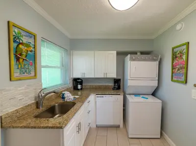 a kitchen with a sink and a refrigerator at Emerald Beach Cottage in Panama City Beach