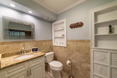 a bathroom with a toilet and a sink at Emerald Beach Cottage in Panama City Beach