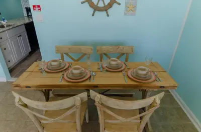 a wooden table with plates and dishes on it at Sunbird 509E 'Window on the Gulf' in Panama City Beach