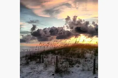 a sunset on the beach with a cloudy sky at Sunbird 509E 'Window on the Gulf' in Panama City Beach