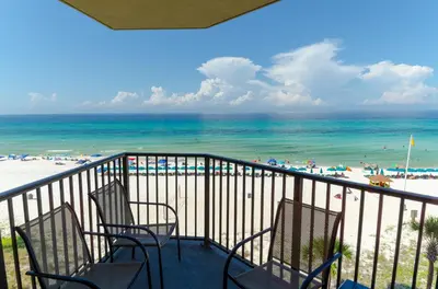 a balcony with chairs and the beach and the ocean at Sunbird 509E 'Window on the Gulf' in Panama City Beach