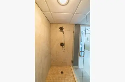 a bathroom with a shower with a glass door at Long Beach T4-1004 'Emerald Retreat' in Panama City Beach