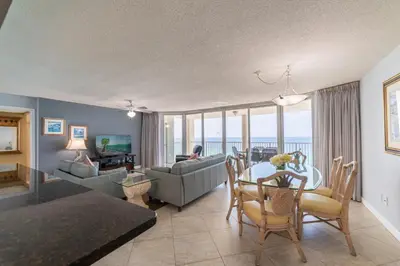 a living room with a table and a couch at Long Beach T4-1004 'Emerald Retreat' in Panama City Beach