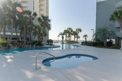 a swimming pool in the middle of a building with palm trees at Long Beach T4-1004 'Emerald Retreat' in Panama City Beach