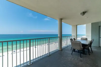 a balcony with a table and chairs and the ocean at Long Beach T4-1004 'Emerald Retreat' in Panama City Beach