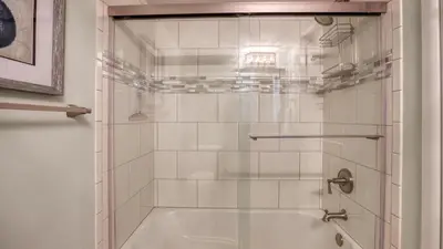 a shower with a glass door in a bathroom at Mariner West 606 'Beach Happy' in Panama City Beach