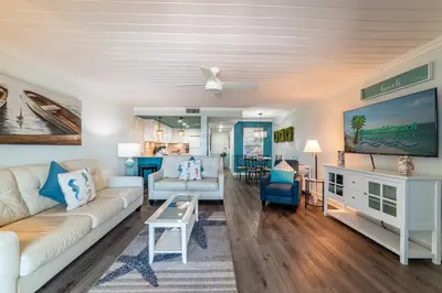 a living room with a couch and a table at Mariner West 606 'Beach Happy' in Panama City Beach