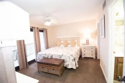 a bedroom with a bed and a dresser and a window at Commodore 1303 'Rest Ashored' in Panama City Beach