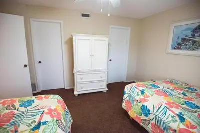 a bedroom with a bed and a dresser in it at Commodore 1303 'Rest Ashored' in Panama City Beach