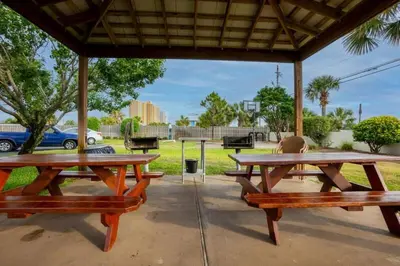 two picnic tables under a pavilion in a park at Commodore 1303 'Rest Ashored' in Panama City Beach