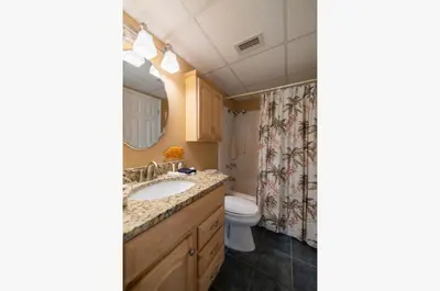 a bathroom with a sink and a toilet at Sunbird 1205W 'Compass Rose Penthouse' in Panama City Beach