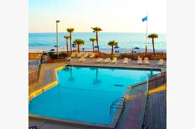 a swimming pool with the ocean in the background at Sunbird 1205W 'Compass Rose Penthouse' in Panama City Beach