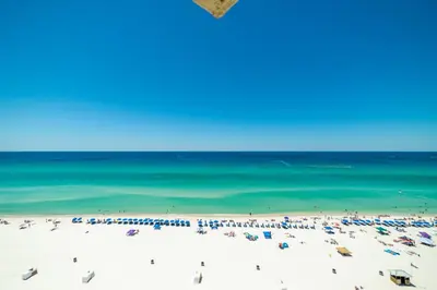 a beach with a crowd of people and the ocean at Sunbird 1205W 'Compass Rose Penthouse' in Panama City Beach