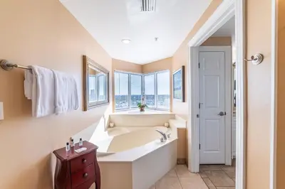a bathroom with a tub and a window at Boardwalk 1101 'Parrothead Paradise' in Panama City Beach