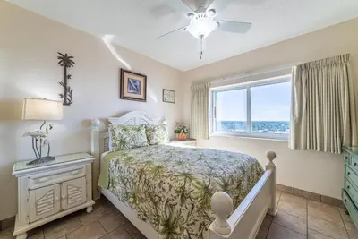 a bedroom with a bed and a window at Boardwalk 1101 'Parrothead Paradise' in Panama City Beach