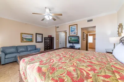 a bedroom with a large bed and a couch at Boardwalk 1101 'Parrothead Paradise' in Panama City Beach