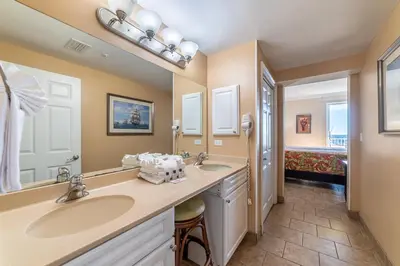 a bathroom with two sinks and two mirrors at Boardwalk 1101 'Parrothead Paradise' in Panama City Beach