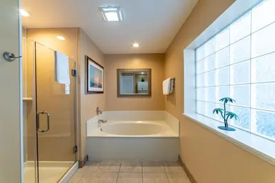 a bathroom with a tub and a window at Boardwalk 1101 'Parrothead Paradise' in Panama City Beach