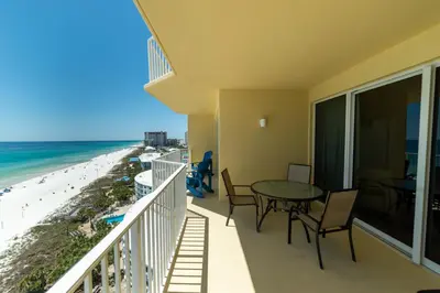 a balcony with a table and chairs and the beach at Boardwalk 1111 'Admiral's Quarters' in Panama City Beach