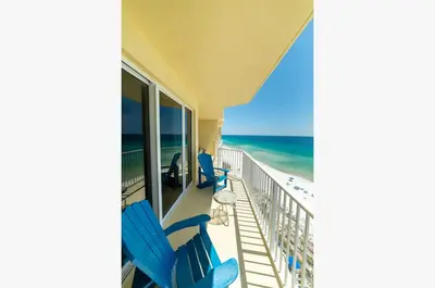 a balcony with blue chairs and a view of the ocean at Boardwalk 1111 'Admiral's Quarters' in Panama City Beach