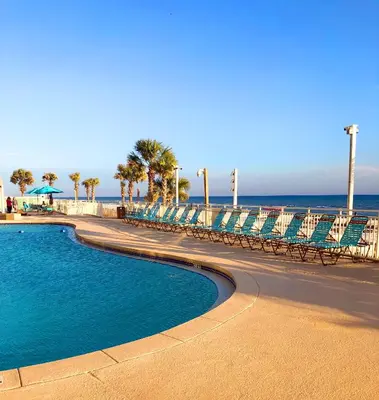 a swimming pool next to a beach with chairs and the ocean at Watercrest 0607 'Sail Away' in Panama City Beach