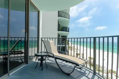 a balcony with a chair and a table and the ocean at Watercrest 0607 'Sail Away' in Panama City Beach
