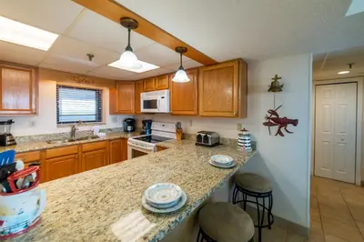 a kitchen with wooden cabinets and a counter top at Watercrest 1004 'Neptune's Reef' in Panama City Beach