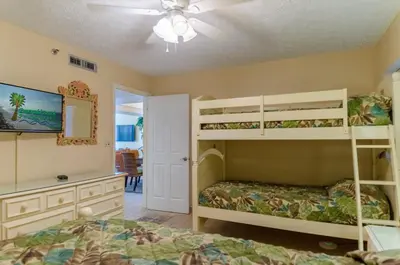 a bedroom with two bunk beds and a ceiling fan at Watercrest 1004 'Neptune's Reef' in Panama City Beach