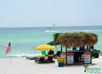 a beach with chairs and an umbrella and the ocean at Watercrest 1507 'Mermaid's Hideaway' in Panama City Beach