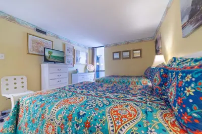 a bedroom with a bed with a colorful bedspread at Edgewater W608 'Sea Forever' in Panama City Beach