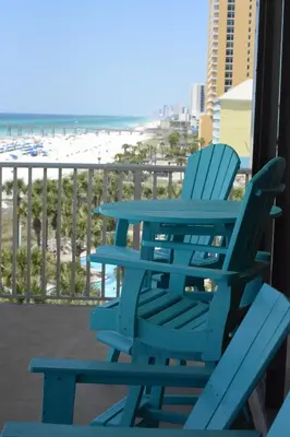 a blue table and chairs on a balcony with the beach at Edgewater W608 'Sea Forever' in Panama City Beach