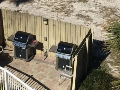 two bbqurgers on a patio next to a fence at Grand Panama 1-1803 'Panama Paradise' in Panama City Beach