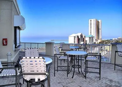 a patio with tables and chairs on a balcony at Grand Panama 1-1803 'Panama Paradise' in Panama City Beach