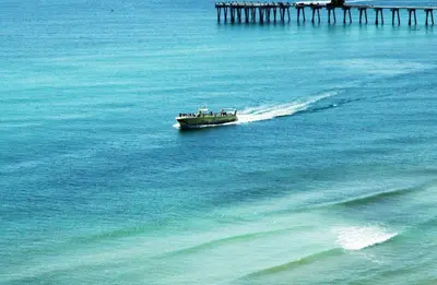 a boat in the water next to a pier at Sunbird 908E 'High Tides' in Panama City Beach
