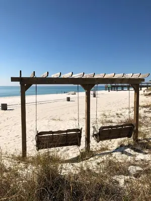 two swings on a beach with the ocean at Sunbird 908E 'High Tides' in Panama City Beach