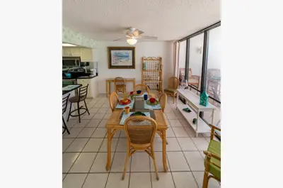 a kitchen and dining room with a table and chairs at Edgewater W607 'Seas The Day' in Panama City Beach