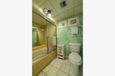 a bathroom with a toilet and a bath tub at Edgewater W607 'Seas The Day' in Panama City Beach