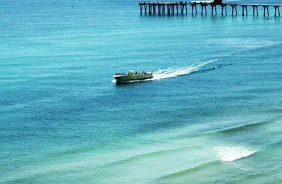 a boat in the water next to a pier at Edgewater W607 'Seas The Day' in Panama City Beach