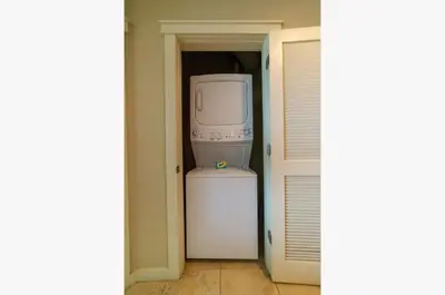 a laundry room with a refrigerator and a washer and dryer at Origin 631 'Sea La Vie' in Panama City Beach