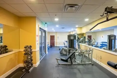 a gym with equipment in a room with yellow walls at Origin 631 'Sea La Vie' in Panama City Beach